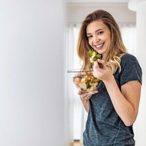 Woman eating a fresh salad, highlighting the role of preconception nutrition in preparing for a healthy pregnancy